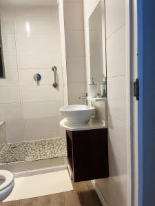 a white bathroom with a sink and a shower at Exclusive Stays @ Rea's Oceanic Hotels in Durban