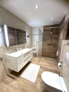 a bathroom with a sink and a shower and a toilet at Landhaus Solaris in Leutasch