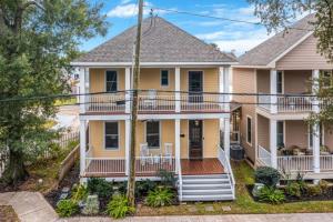 a large yellow house with a porch at Downtown 3 bedroom Townhouse in Lake Charles