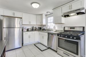 una cocina con armarios blancos y electrodomésticos de acero inoxidable en New Windsor Vacation Rental with Private Yard, en New Windsor