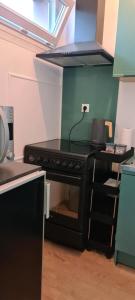 cocina con fogones y horno negro en Studio KAAN avec terasse 5mn Basel Airport, en Saint-Louis 6 fotos más