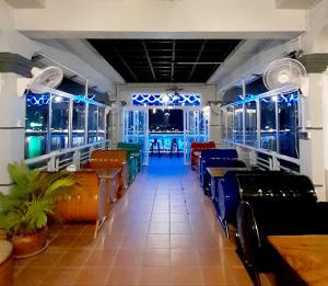 a dining room with chairs and tables and windows at 4 RIVERS HOTEL in Phnom Penh