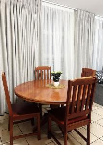 a wooden table with two chairs and a potted plant on top at Exclusive Stays @ Rea's Oceanic Hotels in Durban