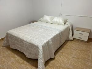 um quarto com uma cama e uma mesa de cabeceira em CASA RURAL SAN GREGORIO em Las Eras