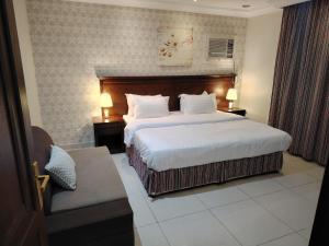 a hotel room with a large bed and a chair at العالية للشقق المفروشه الشهري in Jeddah