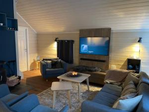 ein Wohnzimmer mit einem Sofa und einem TV in der Unterkunft Trysil Alpin 16A Top location in Trysil