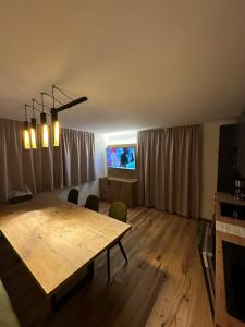 salon z drewnianym stołem i telewizorem w obiekcie Ferienwohnung Krallinger w mieście Wenns
