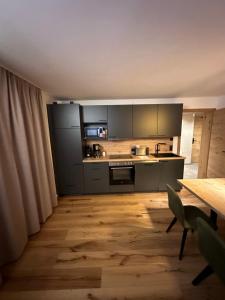 kuchnia z urządzeniami ze stali nierdzewnej i drewnianą podłogą w obiekcie Ferienwohnung Krallinger w mieście Wenns