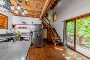 a kitchen with a stainless steel refrigerator and wooden ceilings at Cocolobo Resort in West End