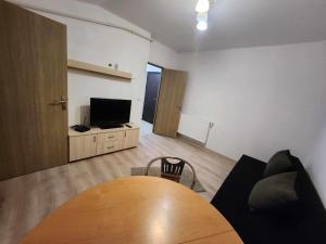 sala de estar con mesa de madera y TV en Dream House Splai Sebeș, en Caransebeş