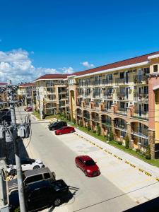 an apartment complex with cars parked in a parking lot at Condo Rentals in Arezzo - 1 Br Condo in Davao City