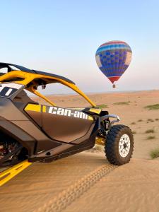 a dirt bike in the desert with a hot air balloon at Dubaicanam Camp in Dubai
