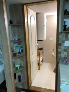 baño con puerta que da a una habitación con cocina en Mia apartmani - novoizgradjeni objekat, en Gornji Milanovac