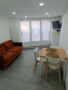 sala de estar con mesa y sofá en Appartement dans maison atypique en Montrond-les-Bains