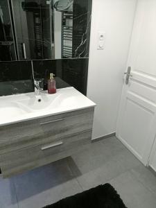 モントロン・レ・バンにあるAppartement dans maison atypiqueのバスルーム(白い洗面台、鏡付)