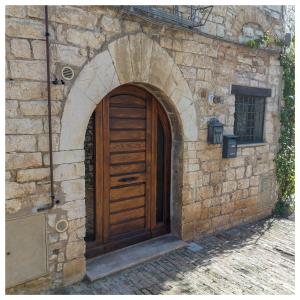 - une entrée pour un bâtiment en pierre avec une porte en bois dans l'établissement Da Bruschi Appartamento Assisi, à Assise