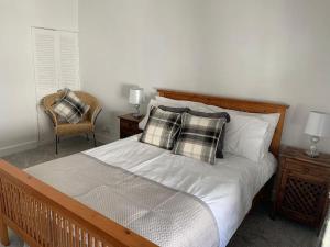 een slaapkamer met een bed met kussens erop bij Cottage nr BikeParkWales/Brecon Beacons/PenYFan in Merthyr Tydfil