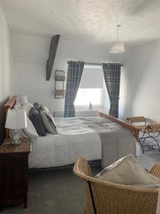 a bedroom with a large bed and a window at Cottage nr BikeParkWales/Brecon Beacons/PenYFan in Merthyr Tydfil