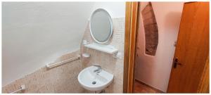 La salle de bains est pourvue d'un lavabo et d'un miroir. dans l'établissement Da Bruschi Appartamento Assisi, à Assise