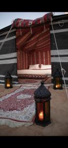 a bedroom with two lamps and a bed with a rug at Dubaicanam Camp in Dubai