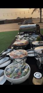 a row of plates of food on a table at Dubaicanam Camp in Dubai