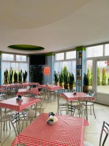 un restaurante con mesas y sillas rojas y blancas en HOTEL MILO - Noclegi Bartoszyce en Bartoszyce