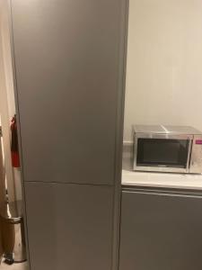 einen Kühlschrank mit einer Mikrowelle auf der Theke in der Unterkunft City centre apartment in Manchester