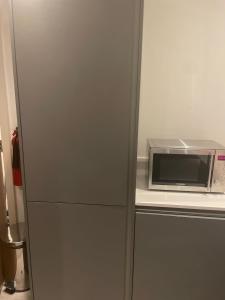 a refrigerator with a microwave on top of a counter at City centre apartment in Manchester +12 photos