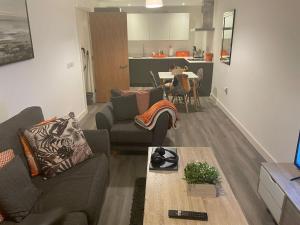 ein Wohnzimmer mit einem Sofa und einem Tisch in der Unterkunft City centre apartment in Manchester