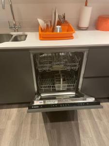 an empty dishwasher in a kitchen with a sink at City centre apartment in Manchester