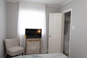 1 dormitorio con 1 cama, TV y silla en Home in Hempstead en Hempstead