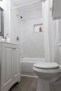 a white bathroom with a toilet and a shower at Home in Hempstead in Hempstead