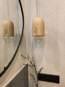 a bathroom mirror with two lights and a vase at Apartments Riese in Neustift im Stubaital
