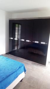 a bedroom with a bed and a large black cabinet at Hostel família Campineira in Campinas