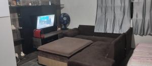 uma sala de estar com um sofá e uma televisão em Hostel família Campineira em Campinas