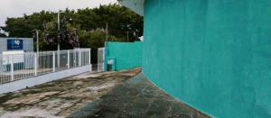 ein Gebäude mit einer grünen Mauer und einem Zaun in der Unterkunft Hostel família Campineira in Campinas