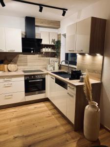 a kitchen with white cabinets and a stove top oven at Apartments Riese in Neustift im Stubaital