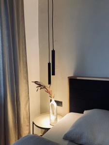 een slaapkamer met een bed en een tafel met een vaas bij Apartments Riese in Neustift im Stubaital