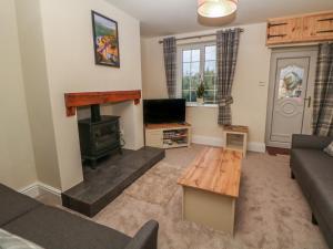 ein Wohnzimmer mit Couch und Ofen in der Unterkunft Quarry Cottage in Buxton