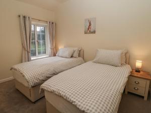 2 camas individuales en una habitación con ventana en Quarry Cottage, en Buxton