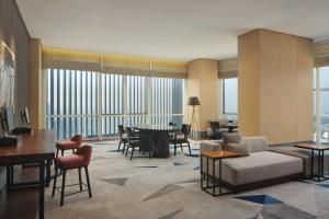 a living room with a couch and a table and chairs at Le Meridien Petaling Jaya in Petaling Jaya