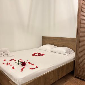 a bed with red rose petals on it at Bonvillas Brezovicë riverside apartments in Brezovica