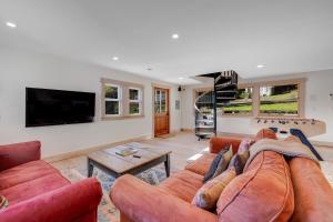 sala de estar con sofá y TV en Mendocino Redwood Retreat - Sunrise Cottage, en Albion