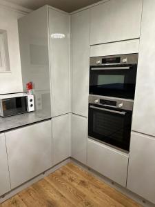 een keuken met witte kasten en een oven bij Seahaven in Sandbanks in Poole