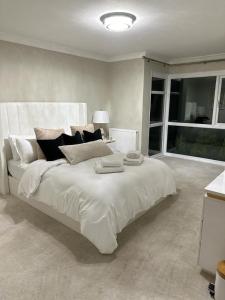 een groot wit bed in een kamer met een raam bij Seahaven in Sandbanks in Poole