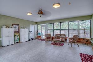 a living room with a table and chairs and windows at Yellow Adirondack Hideaway in Gulfport