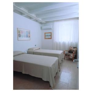 een hotelkamer met twee bedden en een stoel bij skuderia bologna in Bologna