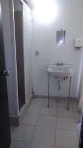 y baño blanco con lavabo y ducha. en Pension Zocalo en Ciudad de México