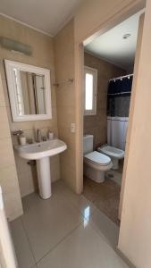 a bathroom with a sink and a toilet and a mirror at Depto moderno a metros de los portones del parque sobre calle Boulogne Sur mer in Mendoza