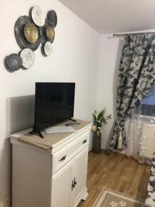 a living room with a tv on a white cabinet at Apartament în regim hotelier familie in Vatra Dornei